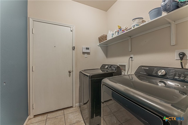 clothes washing area with independent washer and dryer and light tile patterned floors