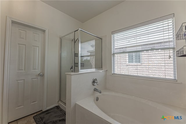 bathroom with shower with separate bathtub and tile patterned floors