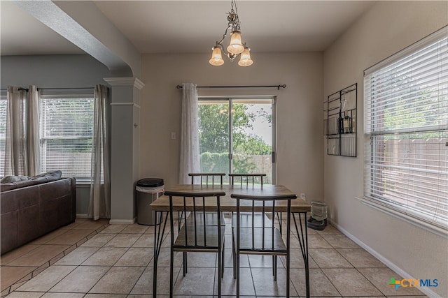 tiled dining area with plenty of natural light and a notable chandelier