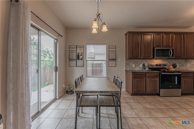 kitchen with stainless steel appliances, a chandelier, light tile patterned floors, tasteful backsplash, and pendant lighting