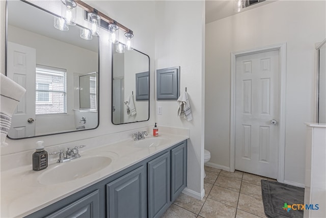 bathroom featuring vanity, a shower with door, tile patterned floors, and toilet