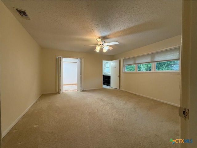 1001 Brookhollow Dr, Port Lavaca, TX 77979 - empty room with ceiling fan, light colored carpet, and a textured ceiling