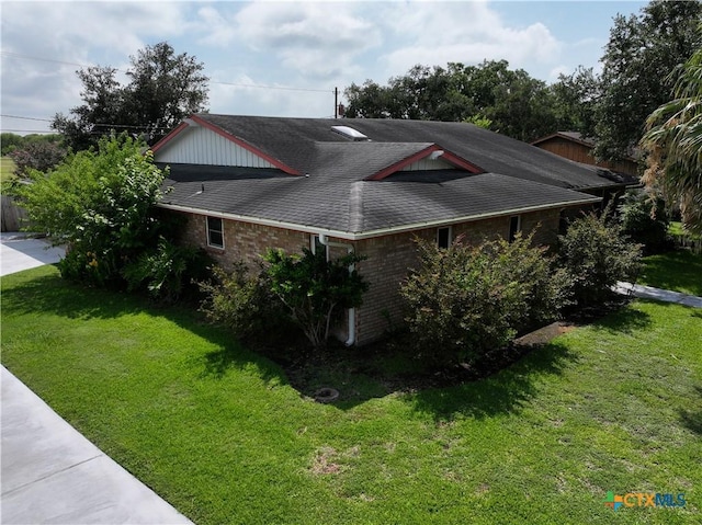 1001 Brookhollow Dr, Port Lavaca, TX 77979 - view of property exterior with a yard, a shingled roof, and brick siding