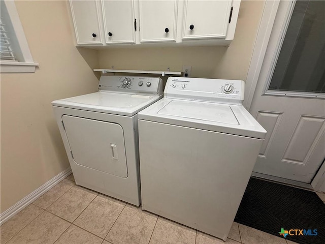 1001 Brookhollow Dr, Port Lavaca, TX 77979 - laundry area featuring washer and dryer, cabinet space, and light tile patterned floors
