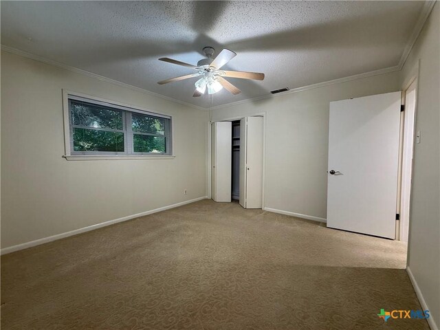 1001 Brookhollow Dr, Port Lavaca, TX 77979 - unfurnished bedroom featuring carpet, ornamental molding, a textured ceiling, a ceiling fan, and a closet