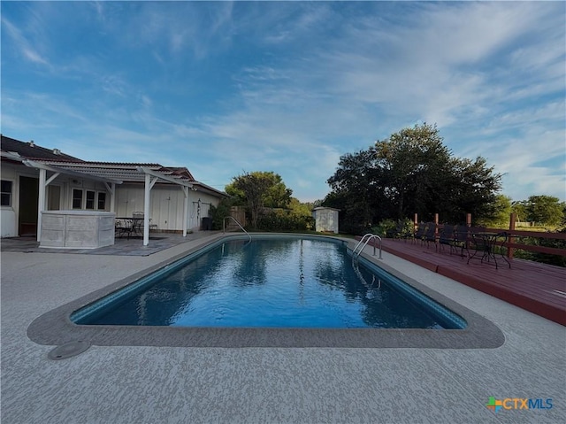 1001 Brookhollow Dr, Port Lavaca, TX 77979 - outdoor pool featuring a wooden deck, a patio, and a pergola