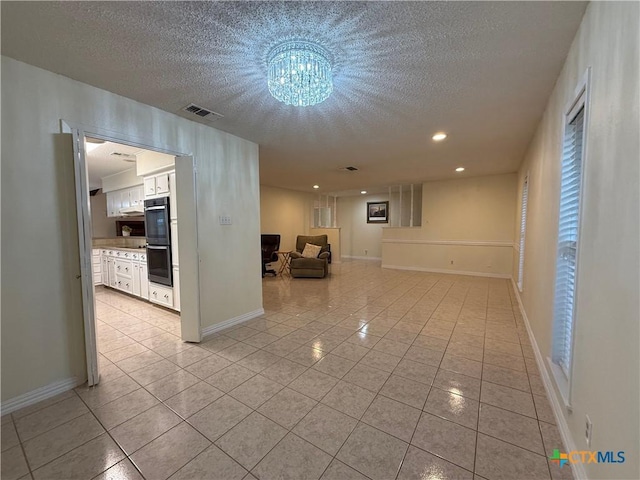 1001 Brookhollow Dr, Port Lavaca, TX 77979 - empty room with light tile patterned flooring, a textured ceiling, a chandelier, and recessed lighting