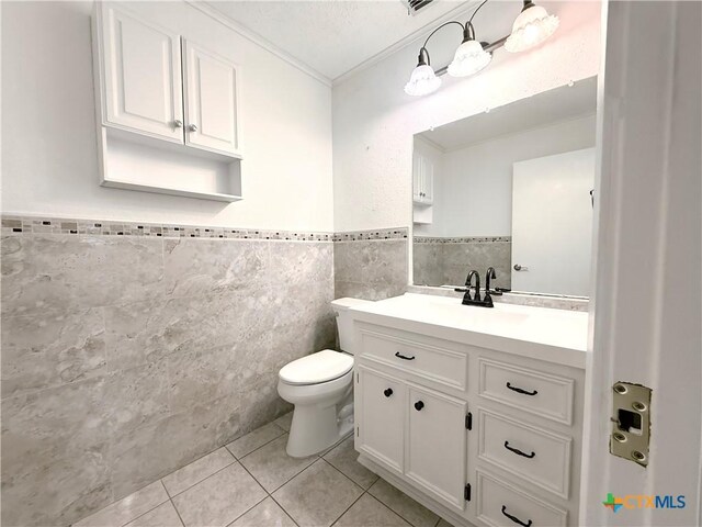 1001 Brookhollow Dr, Port Lavaca, TX 77979 - bathroom with tile walls, ornamental molding, tile patterned flooring, vanity, and a wainscoted wall