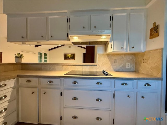 1001 Brookhollow Dr, Port Lavaca, TX 77979 - kitchen with under cabinet range hood, white cabinets, backsplash, black electric cooktop, and light countertops