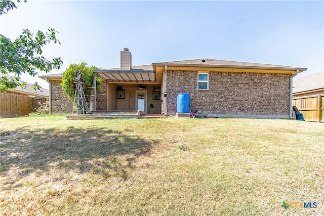 rear view of property featuring a lawn