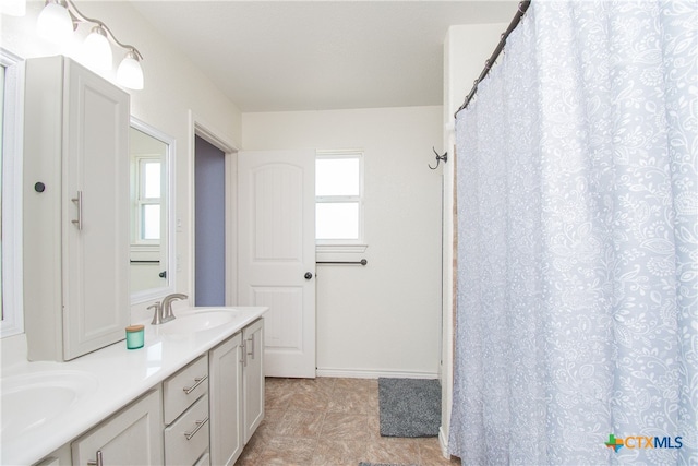 bathroom with walk in shower, vanity, and a wealth of natural light