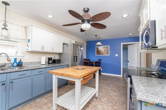 kitchen with white cabinetry, appliances with stainless steel finishes, sink, and hanging light fixtures