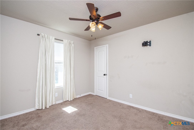 empty room featuring a textured ceiling, light colored carpet, and ceiling fan