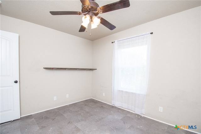 unfurnished room featuring ceiling fan and a textured ceiling