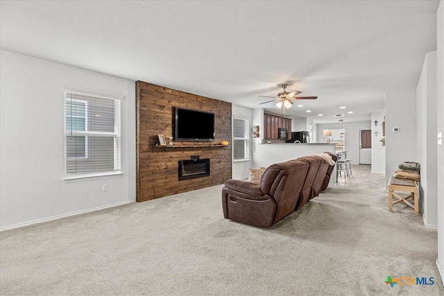 carpeted living room with a fireplace and ceiling fan