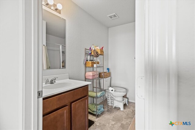 bathroom featuring vanity and toilet