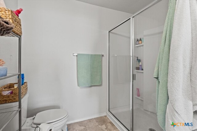 bathroom with toilet and a shower with door