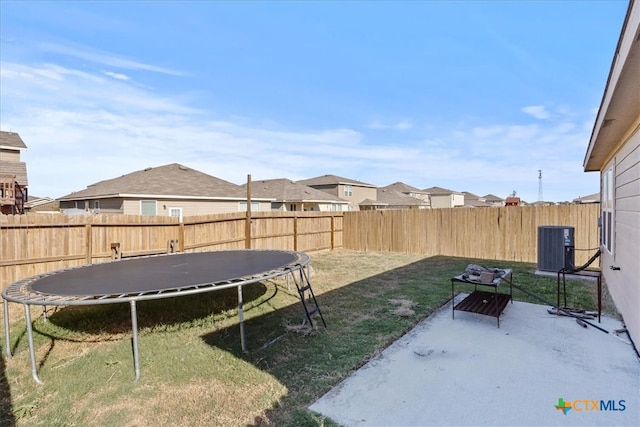 view of yard with central air condition unit, a trampoline, and a patio area