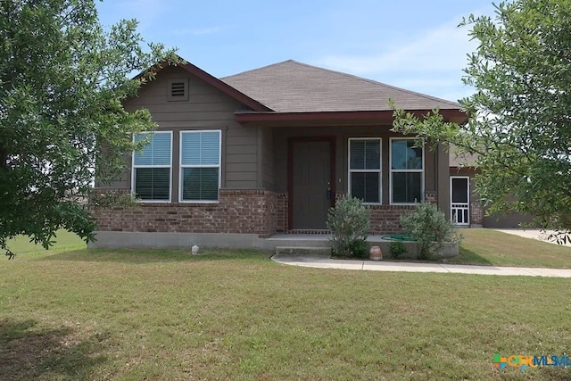 view of front of house featuring brick siding and a front lawn