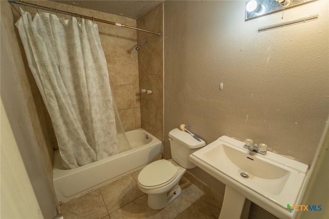 bathroom with tile patterned flooring, toilet, shower / bath combo, and a sink