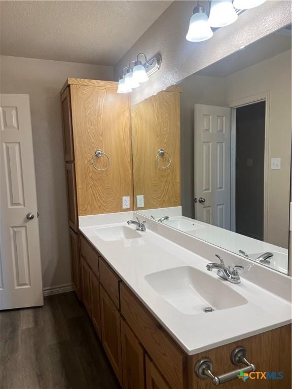 bathroom featuring vanity, wood-type flooring, and a textured ceiling