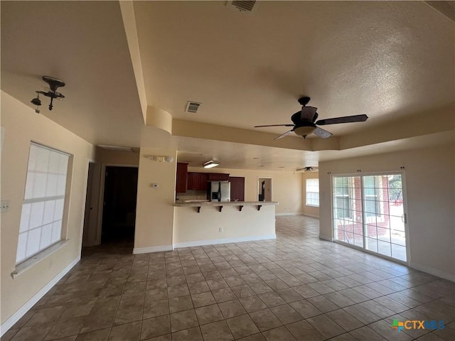 unfurnished living room with ceiling fan and tile patterned floors