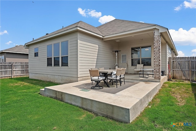 back of house with a patio area and a yard