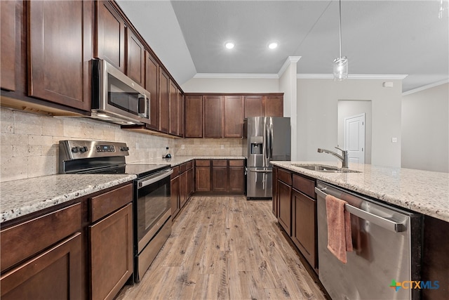 kitchen with light stone countertops, light wood-type flooring, ornamental molding, stainless steel appliances, and pendant lighting