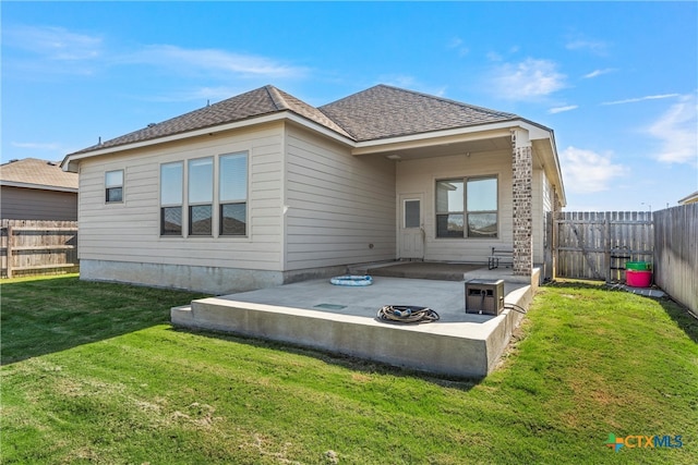 rear view of property with a lawn and a patio