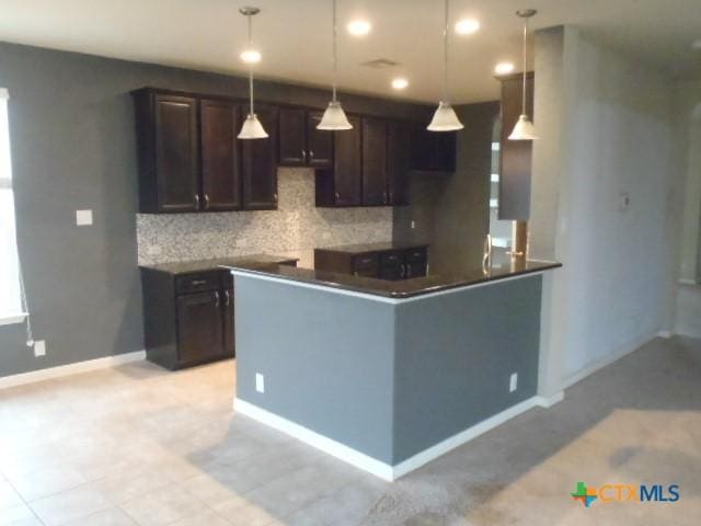 kitchen with pendant lighting, backsplash, dark brown cabinetry, and kitchen peninsula