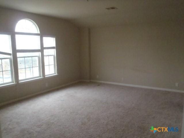 empty room with carpet and lofted ceiling