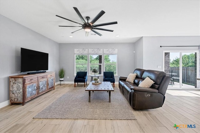 living area featuring healthy amount of natural light, light wood-type flooring, and recessed lighting