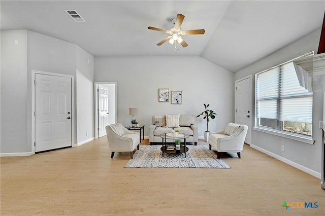 living room featuring light hardwood / wood-style floors, vaulted ceiling, and ceiling fan