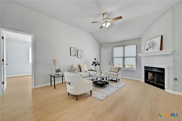 living room featuring ceiling fan, light hardwood / wood-style floors, and lofted ceiling