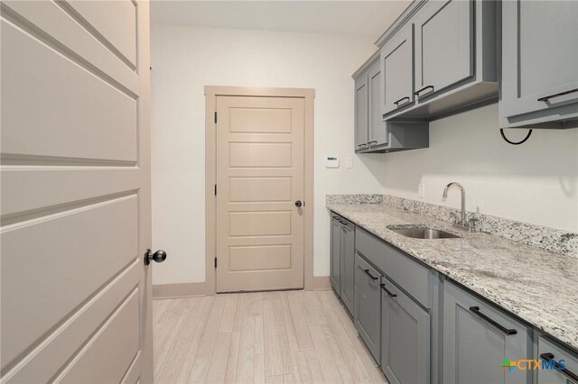 2892 Beulah Blvd, Belton, TX 76513 - laundry room featuring a sink, light wood-style flooring, and baseboards