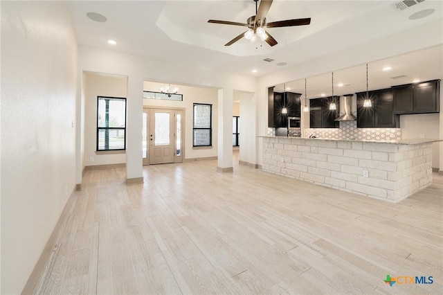 2892 Beulah Blvd, Belton, TX 76513 - unfurnished living room with a chandelier, ceiling fan, light wood-style floors, a tray ceiling, and recessed lighting
