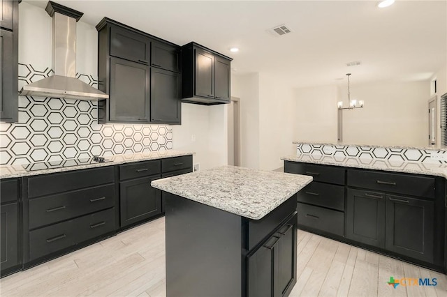 2892 Beulah Blvd, Belton, TX 76513 - kitchen featuring wall chimney range hood, black electric cooktop, light wood-style floors, tasteful backsplash, and a chandelier