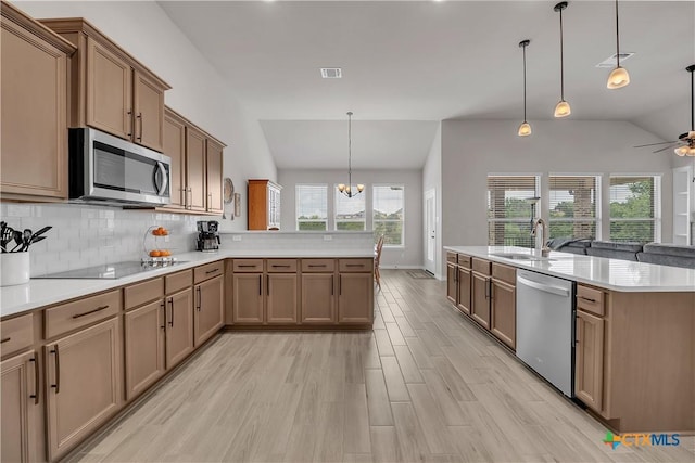 kitchen featuring pendant lighting, sink, decorative backsplash, and appliances with stainless steel finishes