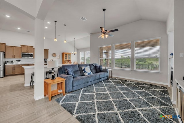 living room featuring ceiling fan, high vaulted ceiling, and light hardwood / wood-style floors