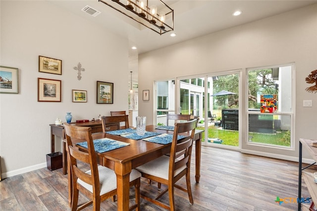 dining area featuring a high ceiling and wood-type flooring