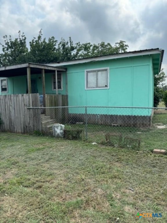 rear view of house featuring a yard