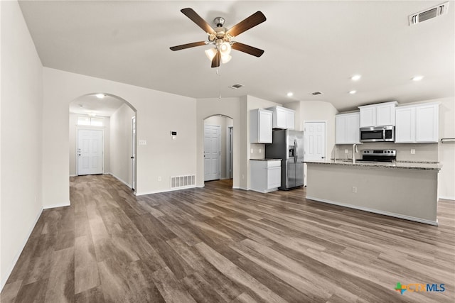 2503 Pintail Loop, Copperas Cove, TX 76522 - kitchen featuring appliances with stainless steel finishes, arched walkways, a ceiling fan, open floor plan, and wood finished floors