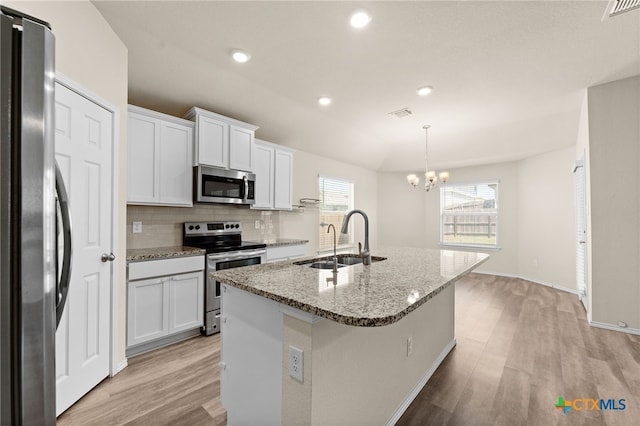 2503 Pintail Loop, Copperas Cove, TX 76522 - kitchen featuring appliances with stainless steel finishes, light wood-style flooring, light stone countertops, a chandelier, and decorative backsplash
