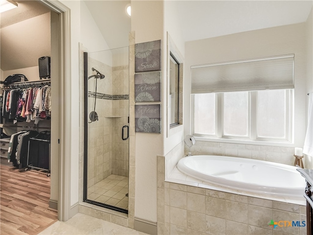 535 Mission Hill Run, New Braunfels, TX 78132 - bathroom featuring a bath, a shower stall, a spacious closet, vaulted ceiling, and wood finished floors
