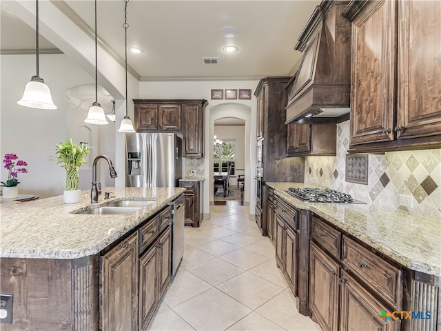 535 Mission Hill Run, New Braunfels, TX 78132 - kitchen featuring stainless steel appliances, a sink, arched walkways, premium range hood, and dark brown cabinets