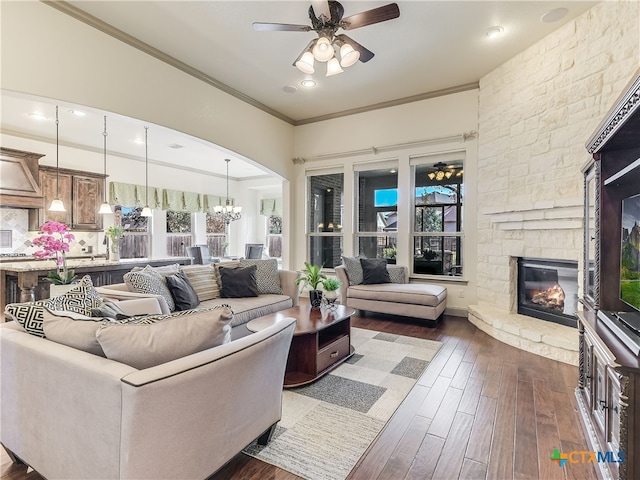 535 Mission Hill Run, New Braunfels, TX 78132 - living area with ceiling fan, a stone fireplace, dark wood-style flooring, ornamental molding, and arched walkways