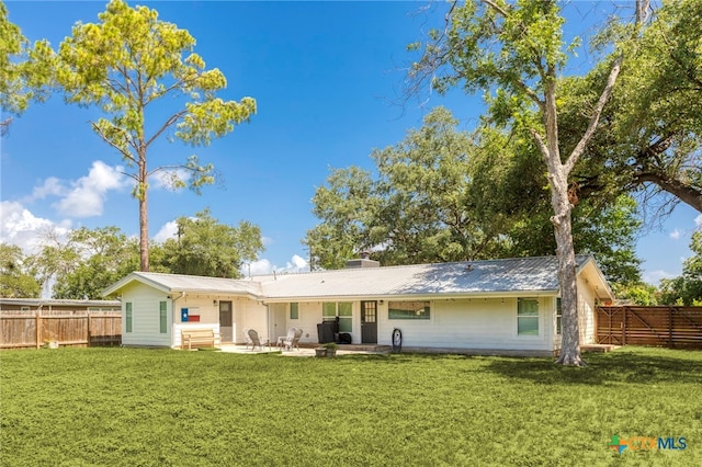 119 W Crockett St, Luling, TX 78648 - back of house featuring a metal roof, a fenced backyard, and a patio area
