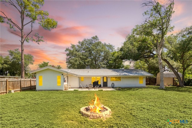 119 W Crockett St, Luling, TX 78648 - rear view of property featuring an outdoor fire pit, a patio area, and a metal roof