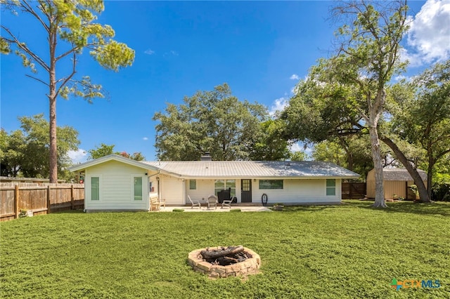 119 W Crockett St, Luling, TX 78648 - back of house featuring a fire pit, a patio area, a metal roof, a storage shed, and a chimney