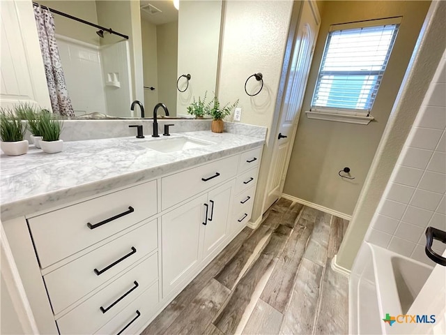 bathroom with vanity, shower / bathtub combination with curtain, and hardwood / wood-style floors